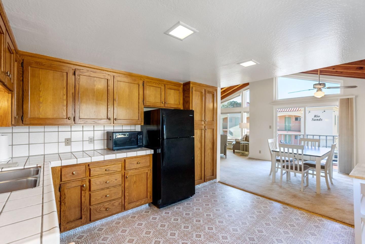 135 Stephen Road Aptos, CA 95003 - Photo 15 of 44 a kitchen with stainless steel appliances granite countertop a refrigerator and wooden cabinets