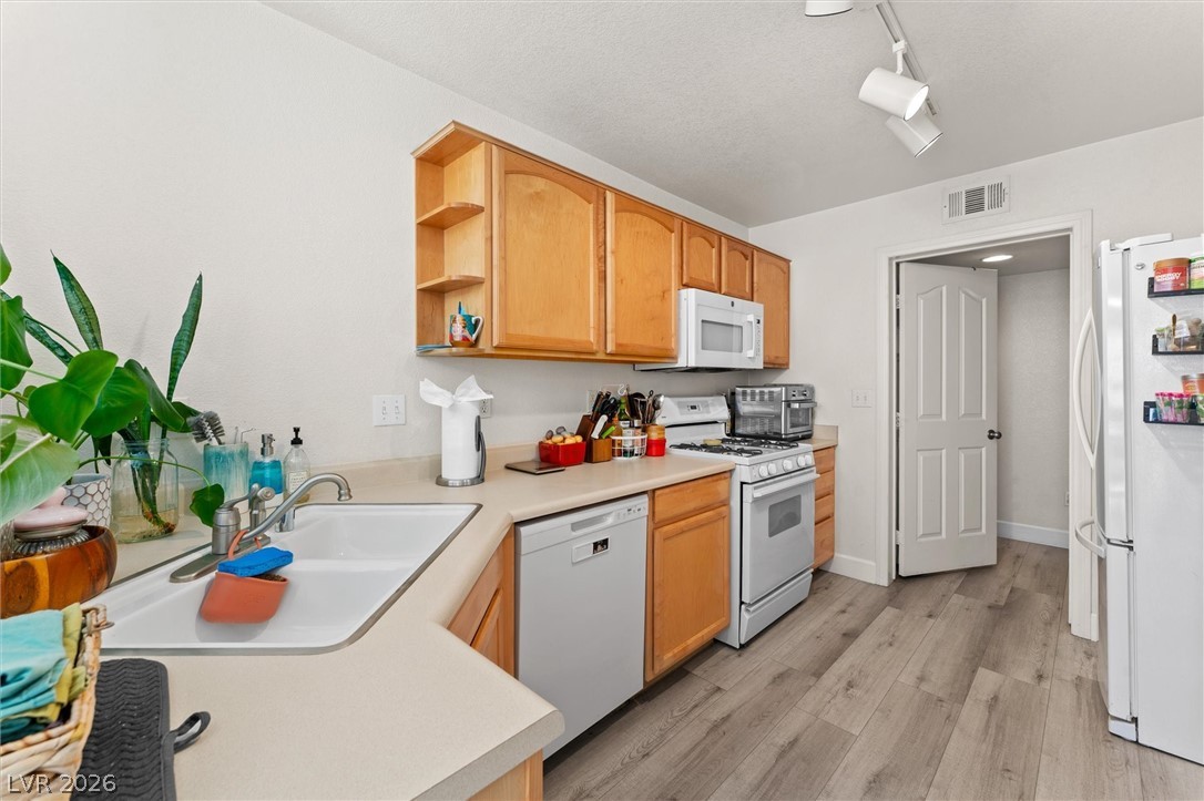 503 Rafkin Place Henderson, NV 89052 - Photo 4 of 18 A well-equipped culinary space boasts light wood cabinetry and resilient plank flooring.