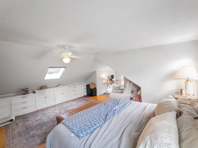 a bedroom with a bed and a lamp on dresser