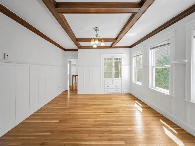 a big room with chandelier fan and windows