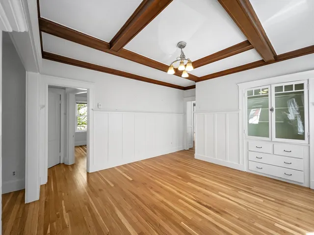 a view of a livingroom with wooden floor and a ceiling fan