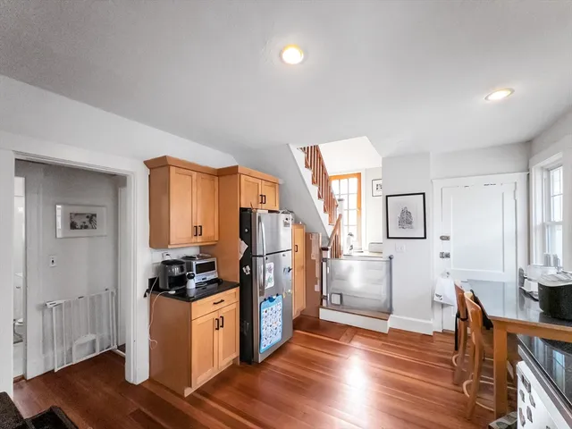 a kitchen with a refrigerator and wooden cabinets