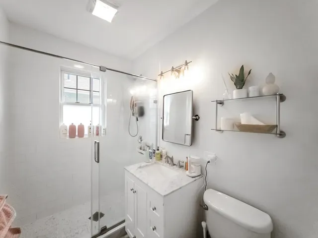 a bathroom with a sink a toilet and shower