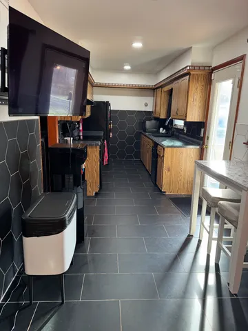 a kitchen with granite countertop a stove a sink and a refrigerator