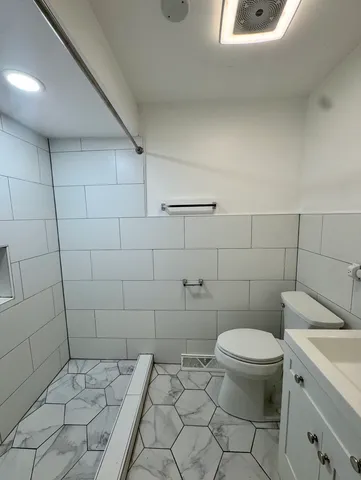 a white toilet sitting next to a bathroom sink