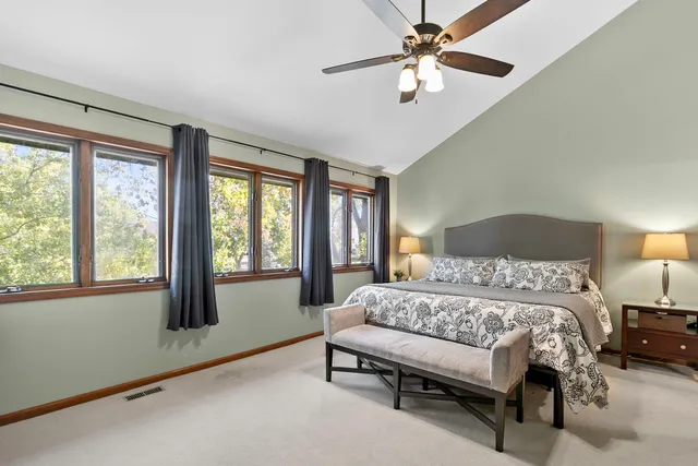 a bedroom with a bed and a chandelier fan