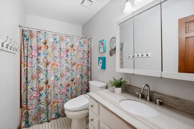 a bathroom with a granite countertop sink a toilet and a mirror