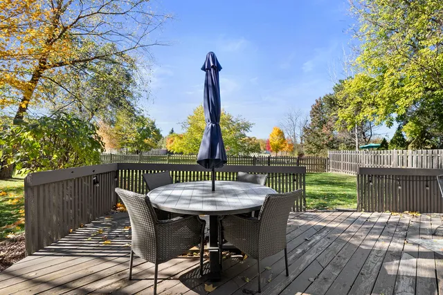 a view of a roof deck with table and chairs a barbeque with wooden fence