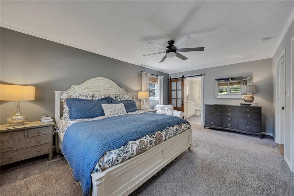 1424 Ridgeway Drive Northwest Acworth, GA 30102 - Photo 20 of 38 a bedroom with a bed a chandelier and dresser