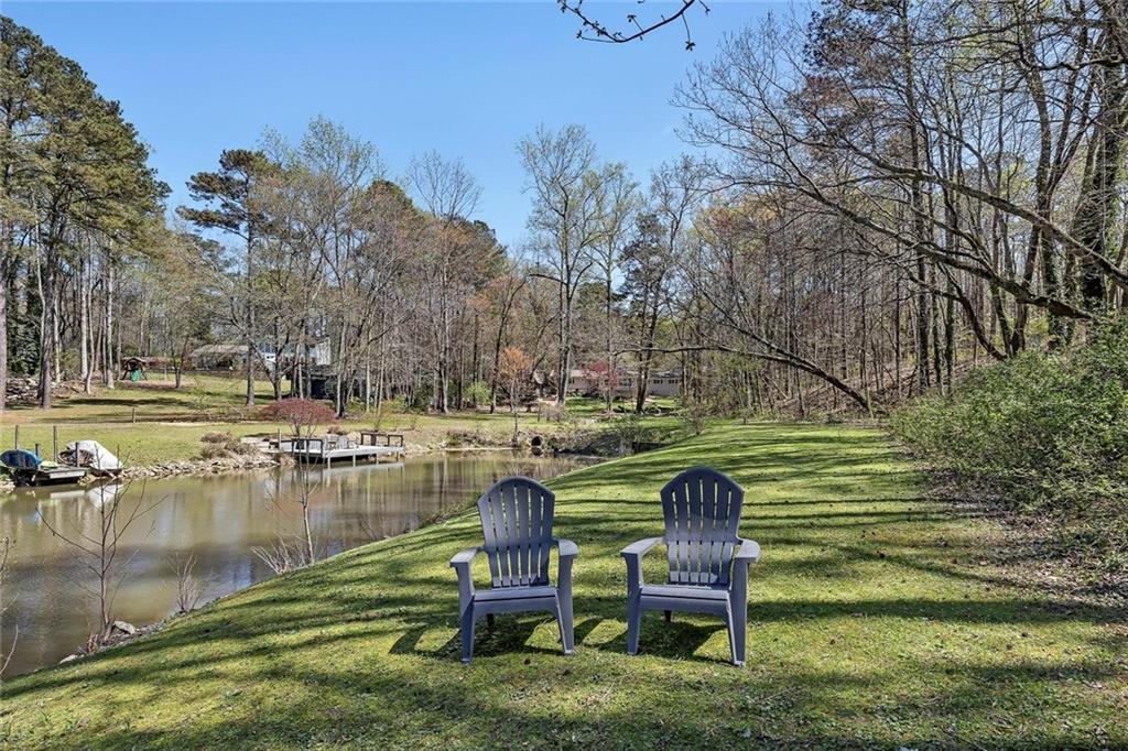 1424 Ridgeway Drive Northwest Acworth, GA 30102 - Photo 32 of 38 a view of a lake with outdoor seating and trees in the background