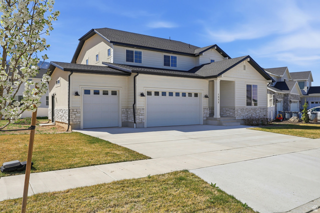 1353 Mapleton Hts Court Mapleton, UT 84664 - Photo 2 of 50 View of front of home featuring stone siding, driveway, a front yard, and roof with shingles