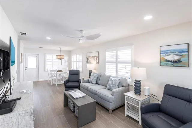 a living room with furniture wooden floor and a large window