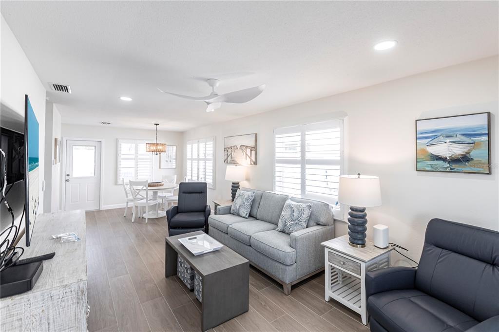 6020 Midnight Pass Road, Unit 29 Sarasota, FL 34242 - Photo 2 of 16 a living room with furniture wooden floor and a large window