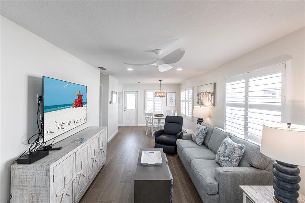6020 Midnight Pass Road, Unit 29 Sarasota, FL 34242 - Photo 4 of 16 a living room with furniture a flat screen tv and a large window