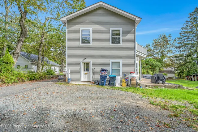 a view of a house with a yard and large tree