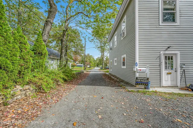 a view of a house with backyard and trees