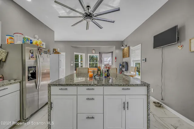 a kitchen with stainless steel appliances granite countertop a refrigerator and a sink