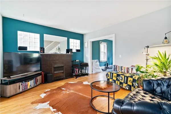 a living room with furniture a flat screen tv and a floor to ceiling window