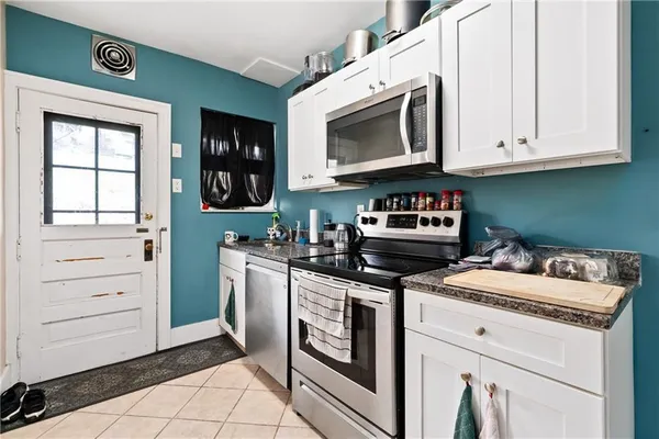 a kitchen with stainless steel appliances granite countertop a stove and a microwave