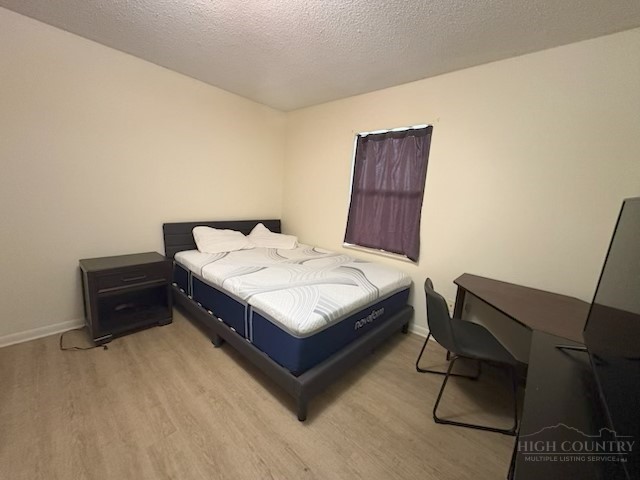 229 East King Street, Unit 31 Boone, NC 28607 - Photo 18 of 26 a bedroom with a bed and chair
