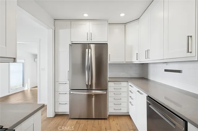 a kitchen with kitchen island white cabinets and stainless steel appliances