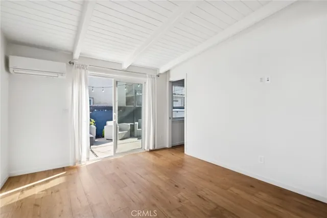 an empty room with wooden floor and door