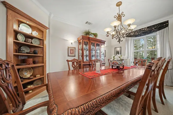 a kitchen with kitchen island granite countertop a table chairs microwave and cabinets