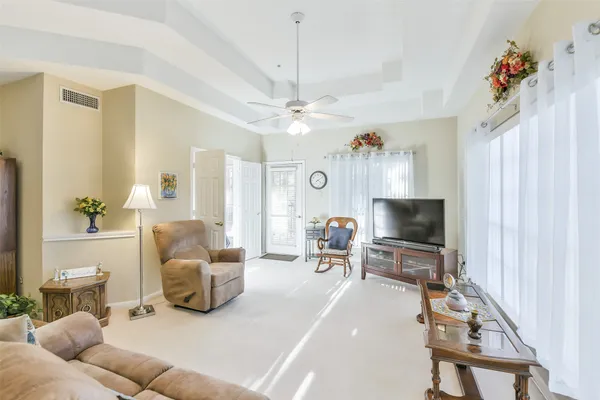 a living room with furniture a chandelier and a flat screen tv