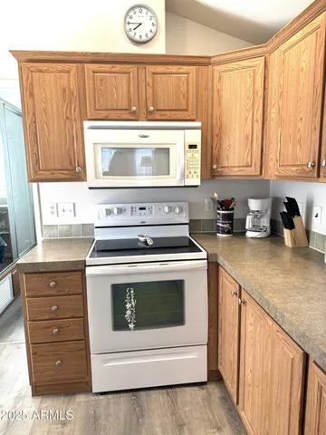 a kitchen with granite countertop white cabinets and white appliances