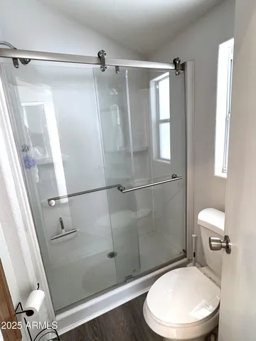 a white toilet sitting next to a shower