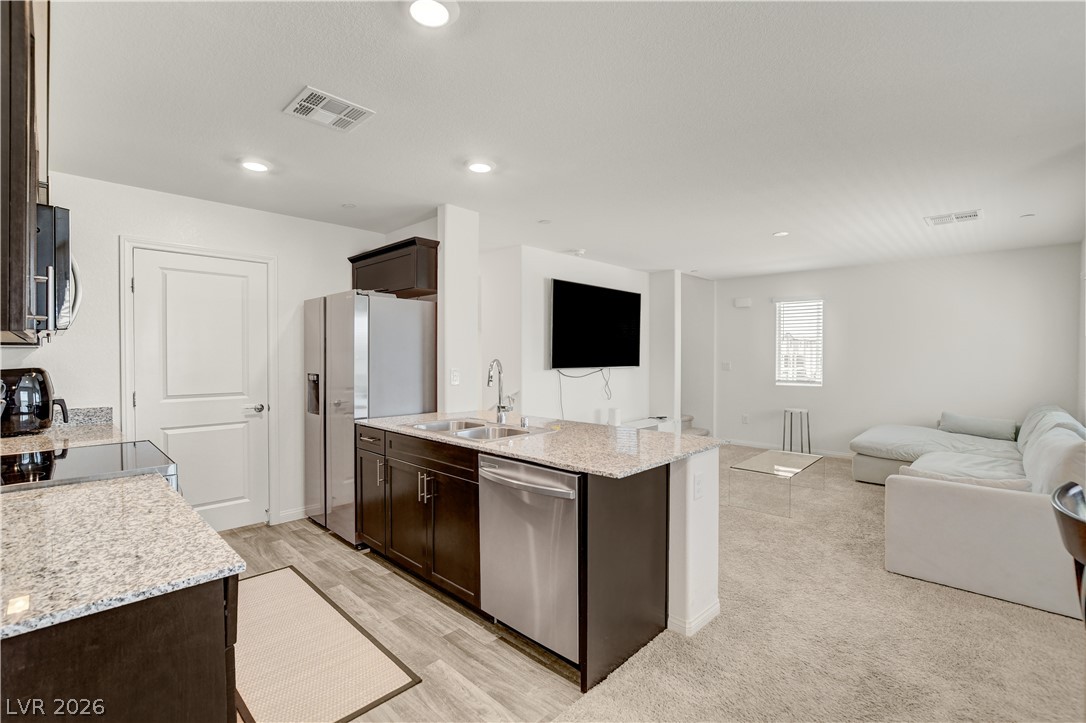 6924 Spicy Merlot Street North Las Vegas, NV 89086 - Photo 15 of 83 An open-concept living area features a well-appointed kitchen with an island, perfect for entertaining.