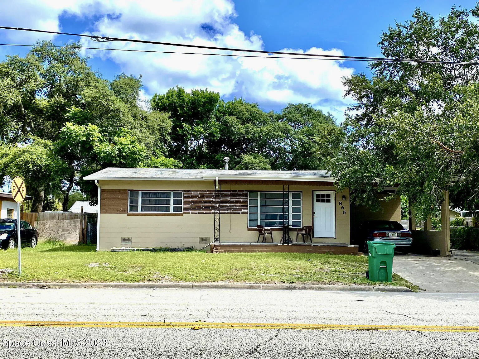 a front view of a house with a yard and potted plants