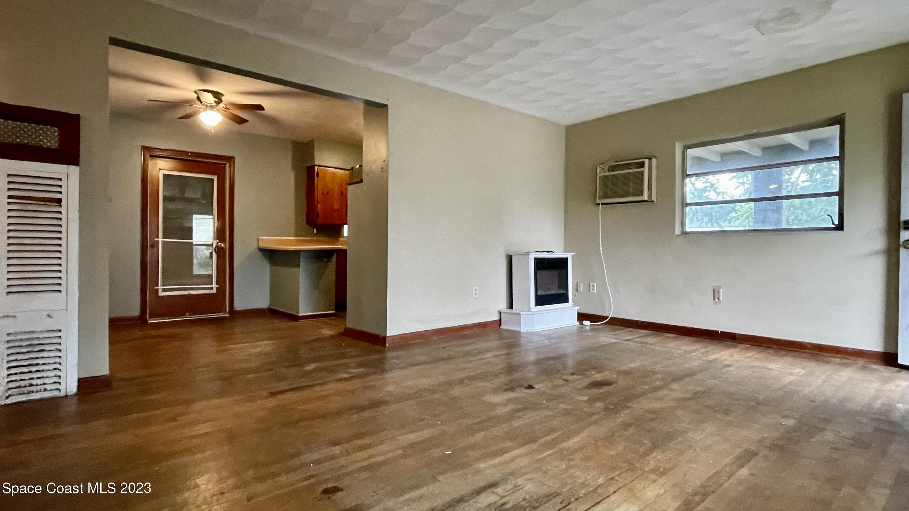 866 Sarno Road Melbourne, FL 32935 - Photo 4 of 19 an empty room with wooden floor and windows