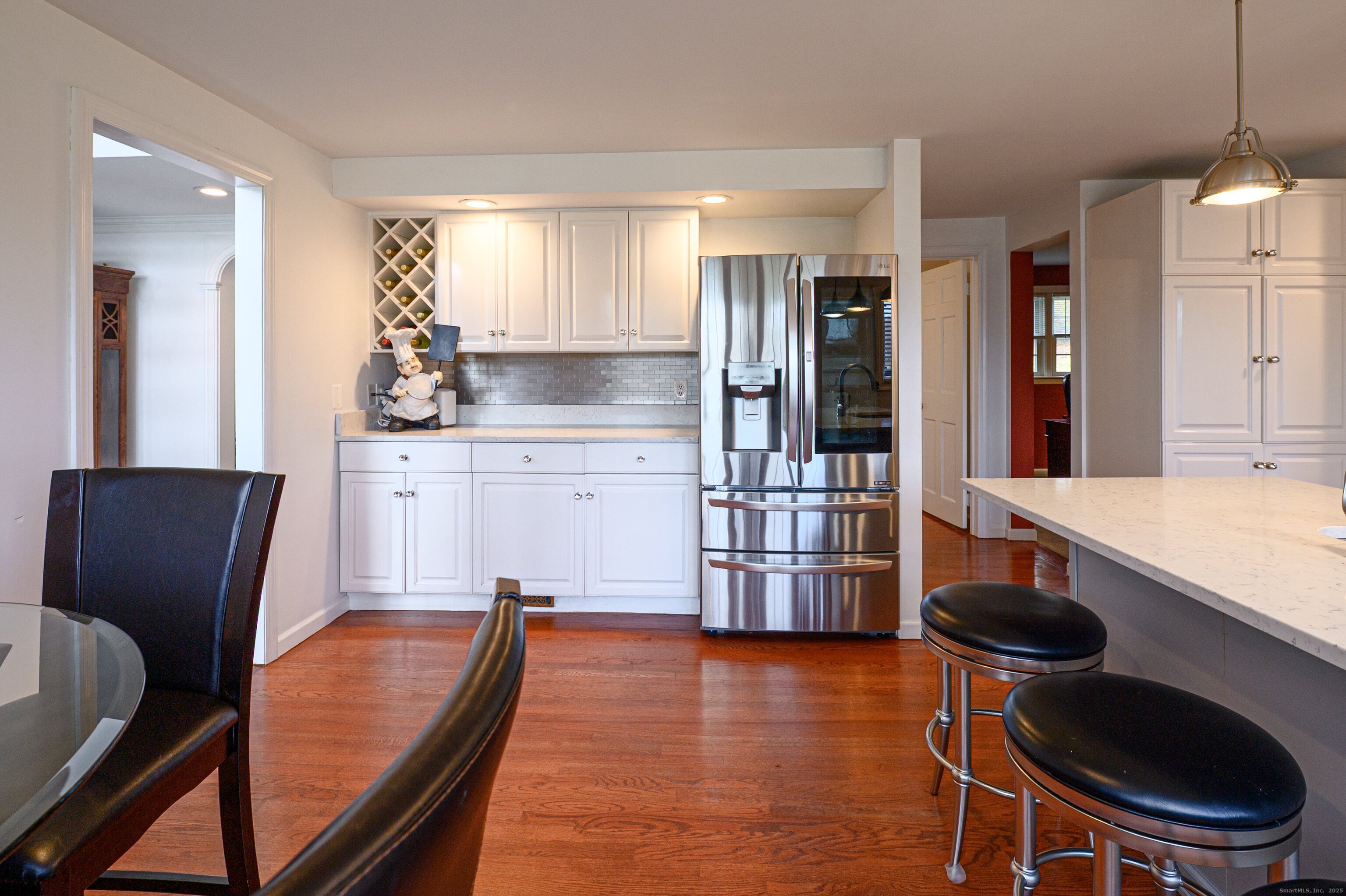 15 Griffing Pond Road Branford, CT 06405 - Photo 22 of 40 a kitchen with stainless steel appliances granite countertop a table chairs in it and wooden floors