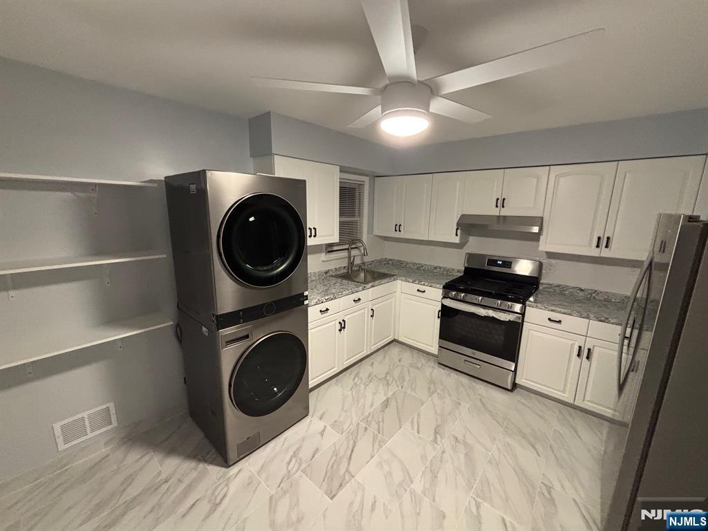47 Cooper Street Bergenfield, NJ 07621 - Photo 12 of 12 a kitchen with a stove a microwave and cabinets