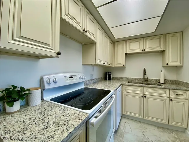 a kitchen with stainless steel appliances granite countertop a sink stove and cabinets