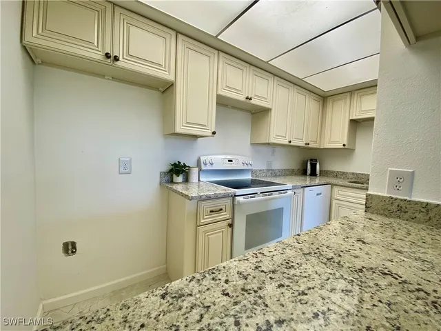 a kitchen with stainless steel appliances granite countertop a sink dishwasher stove and refrigerator