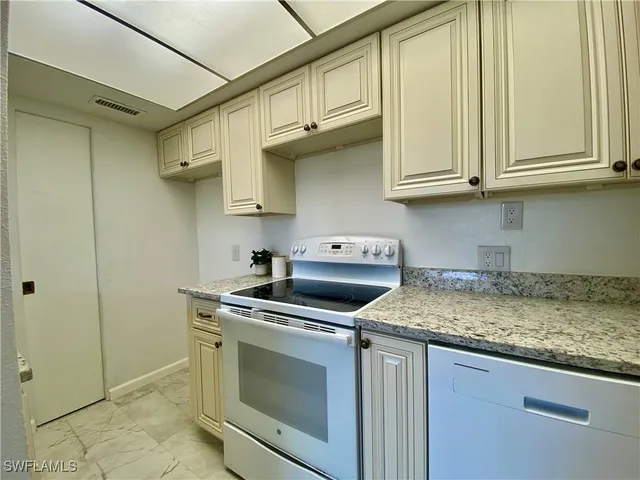 a kitchen with stainless steel appliances granite countertop a sink stove and cabinets
