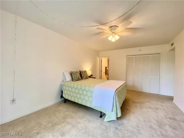 a bedroom with a bed and a chandelier fan