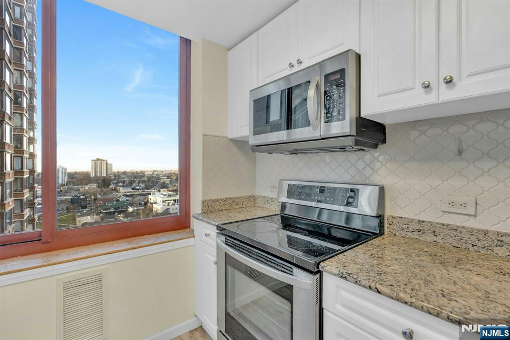 100 Old Palisade Road, Unit 3101 Fort Lee, NJ 07024 - Photo 11 of 28 a kitchen with a stove and a microwave
