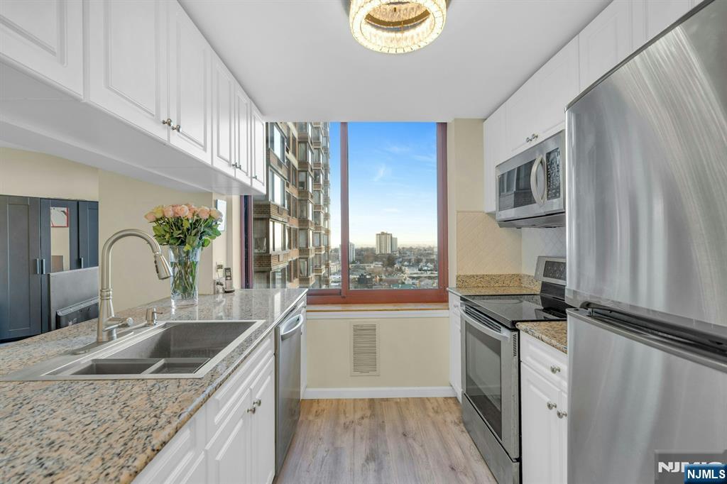 100 Old Palisade Road, Unit 3101 Fort Lee, NJ 07024 - Photo 8 of 28 a kitchen with a sink stove and microwave