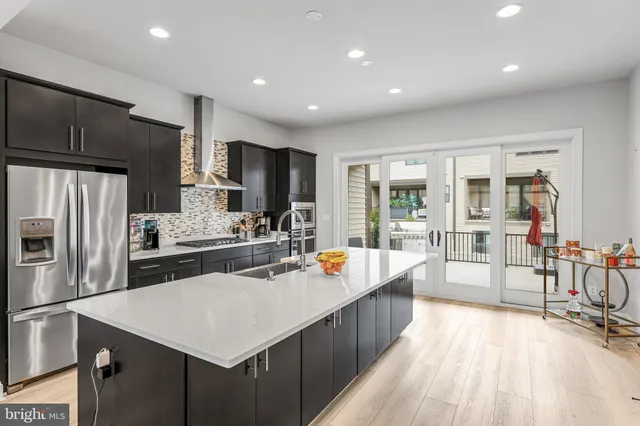 a kitchen with a refrigerator a sink and a stove top oven
