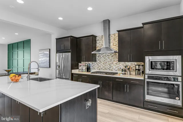 a kitchen with stainless steel appliances a sink stove and refrigerator