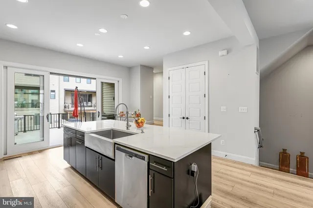 a view of kitchen island a sink wooden floor and living room