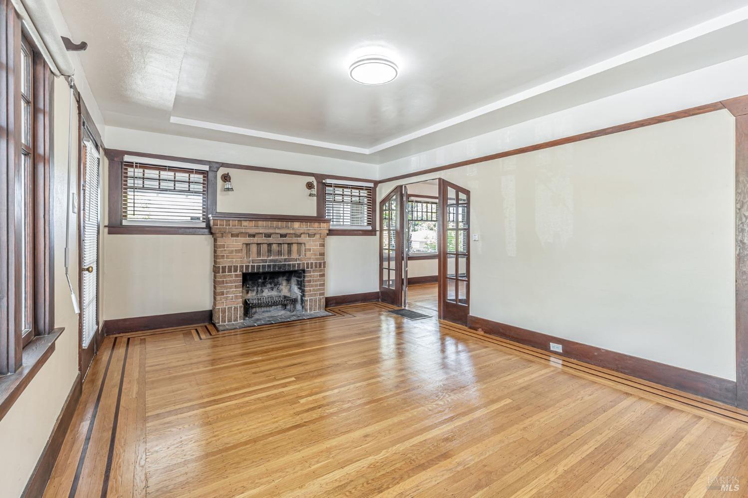 1528 Sutter Street Vallejo, CA 94590 - Photo 9 of 33 an empty room with wooden floor fireplace and windows
