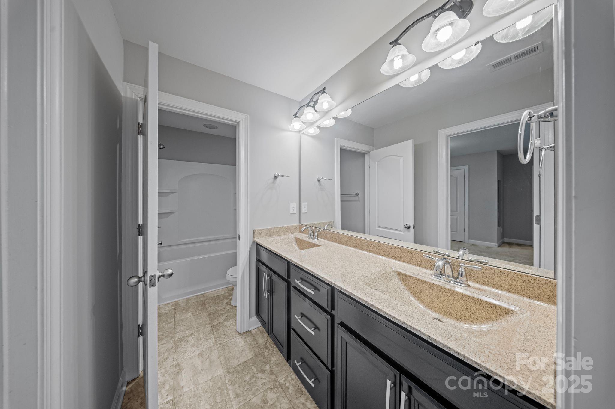 1433 Cilantro Court Tega Cay, SC 29708 - Photo 22 of 42 a bathroom with a granite countertop double vanity sink and a mirror