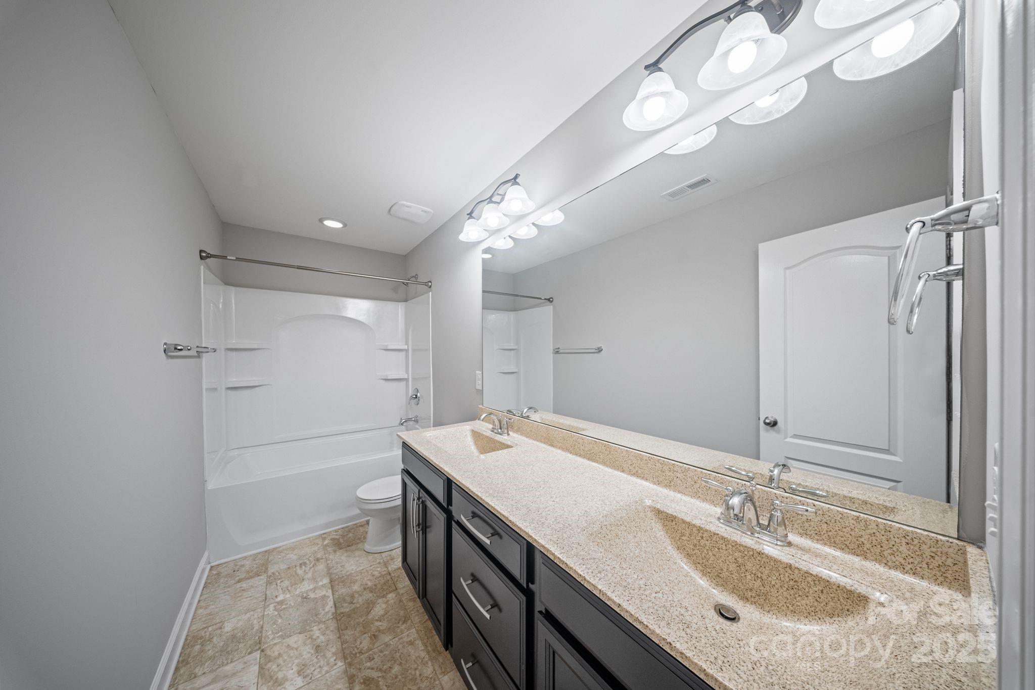 1433 Cilantro Court Tega Cay, SC 29708 - Photo 28 of 42 a bathroom with a sink a mirror and a shower