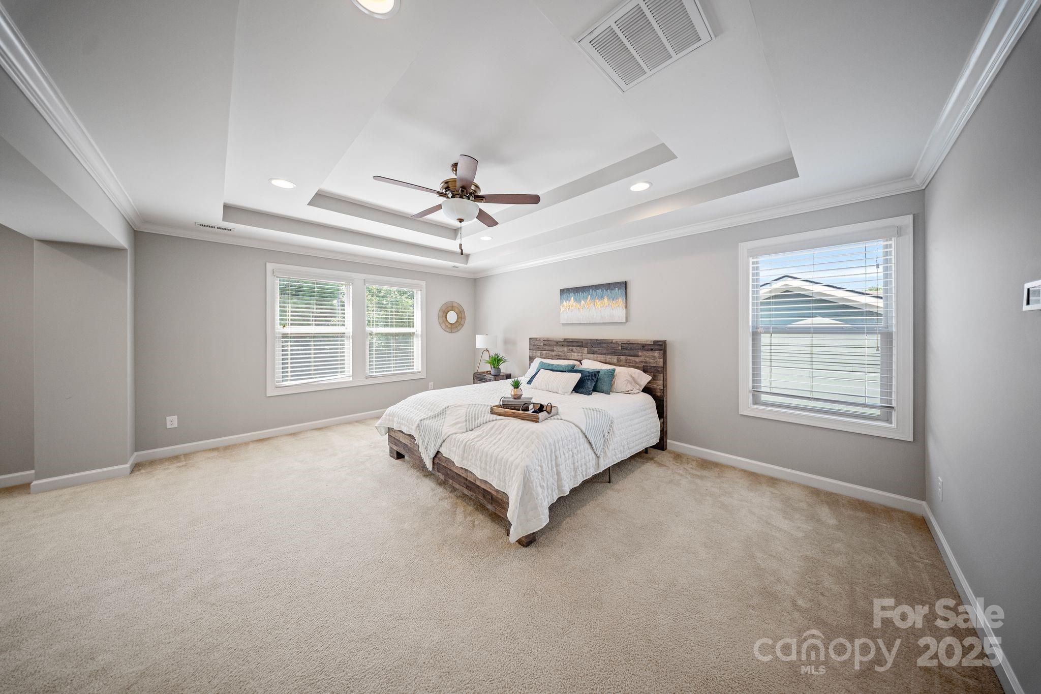 1433 Cilantro Court Tega Cay, SC 29708 - Photo 32 of 42 a bed sitting in a spacious bedroom next to a window and a chandelier