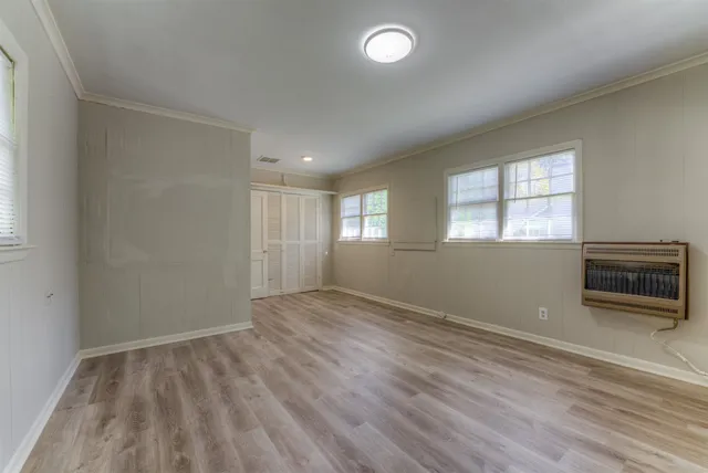 an empty room with windows and fireplace