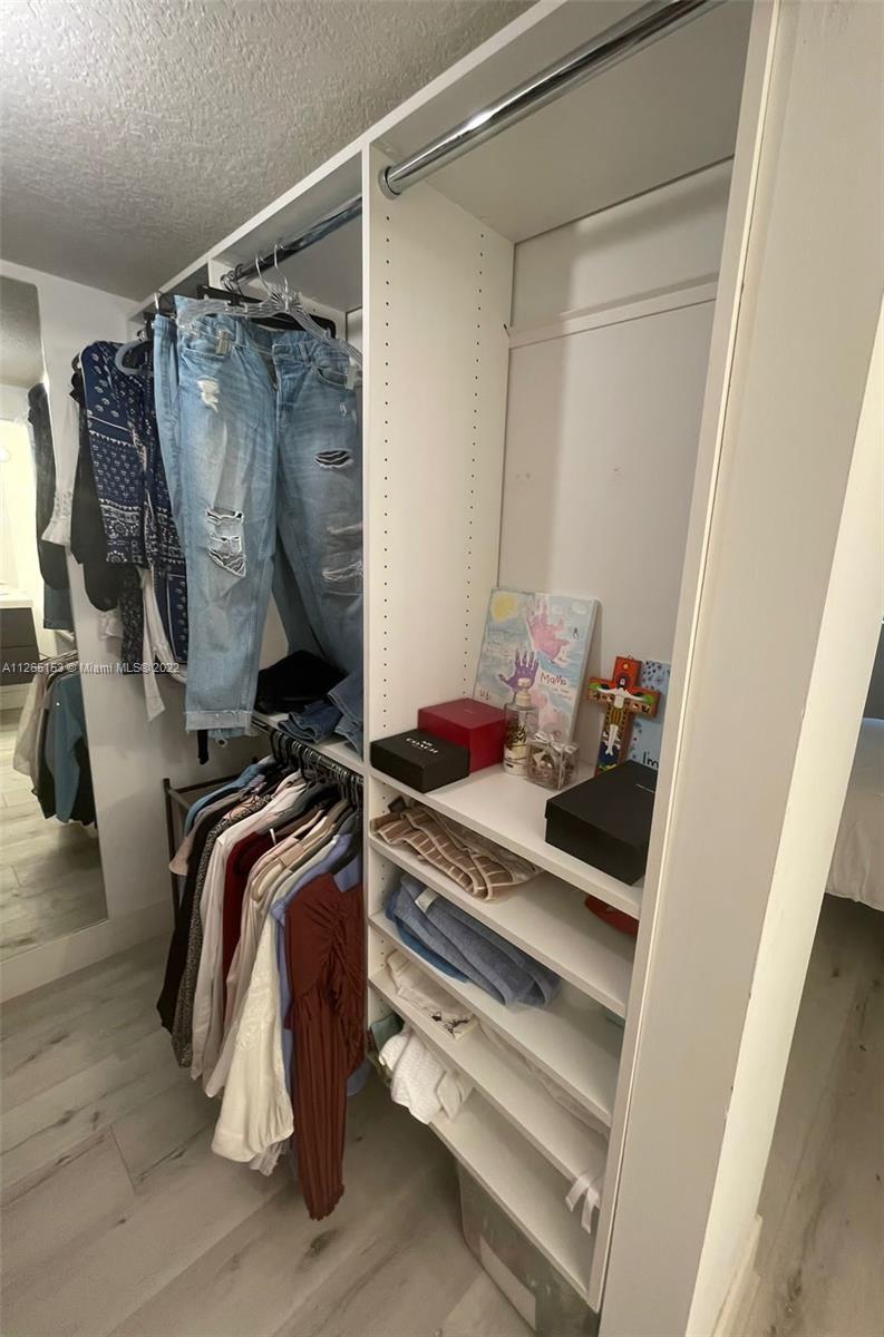4242 Northwest 2nd Street, Unit 708 Miami, FL 33126 - Photo 11 of 20 a view of walk in closet with clothes and shoes
